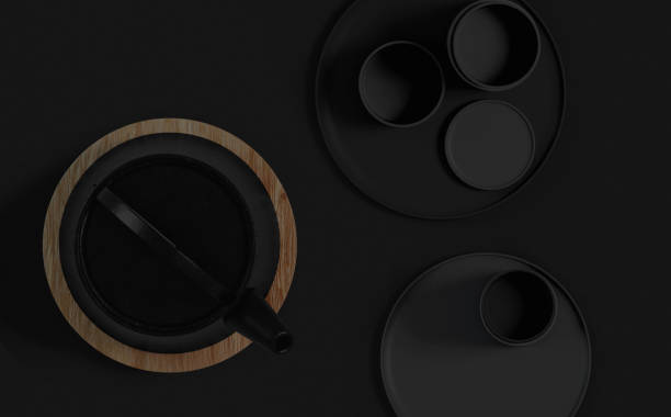 istock Modern black cast iron teapot and tea cups and a balck minimalist table. Top view, set for tea time. 3d rendering. 1236746257