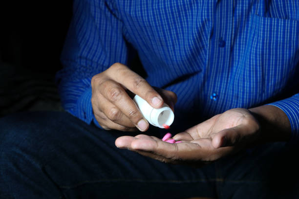 istock young man hand's taking medicine, close up 1236767596