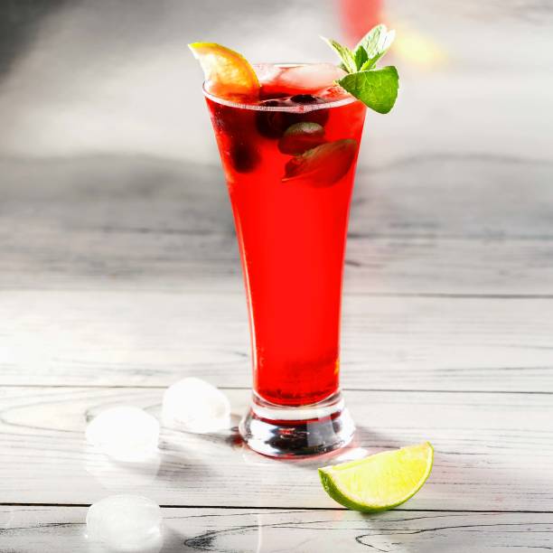 istock Cold drink with cherry and lemon in glass on wooden table. Square image. 1236803628
