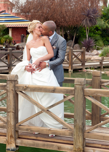 Close up of a Bride and Groom on a wooden bridge kissing
