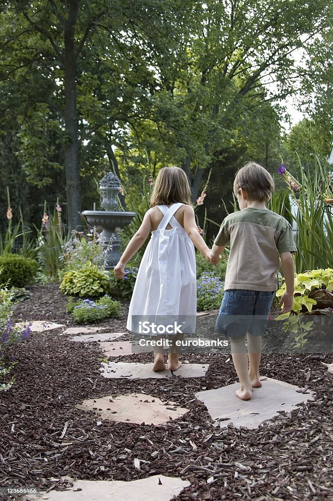 Children in the Garden Children holding hands walking down a garden path. Child Stock Photo