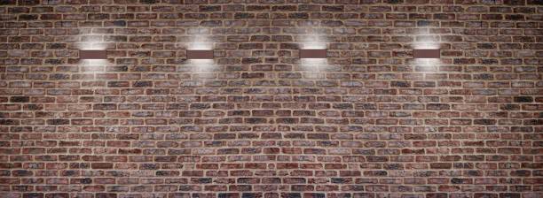 breite rote ziegelwand und lampen mit indirektem licht. moderner industrieller innenhintergrund - accent wall stock-fotos und bilder