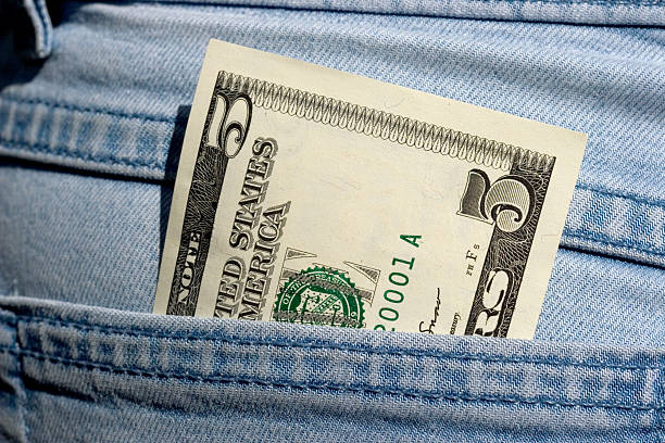 Dollars series Macro of a new US five dollar bill in a jeans pocket. five dollar bill stock pictures, royalty-free photos & images