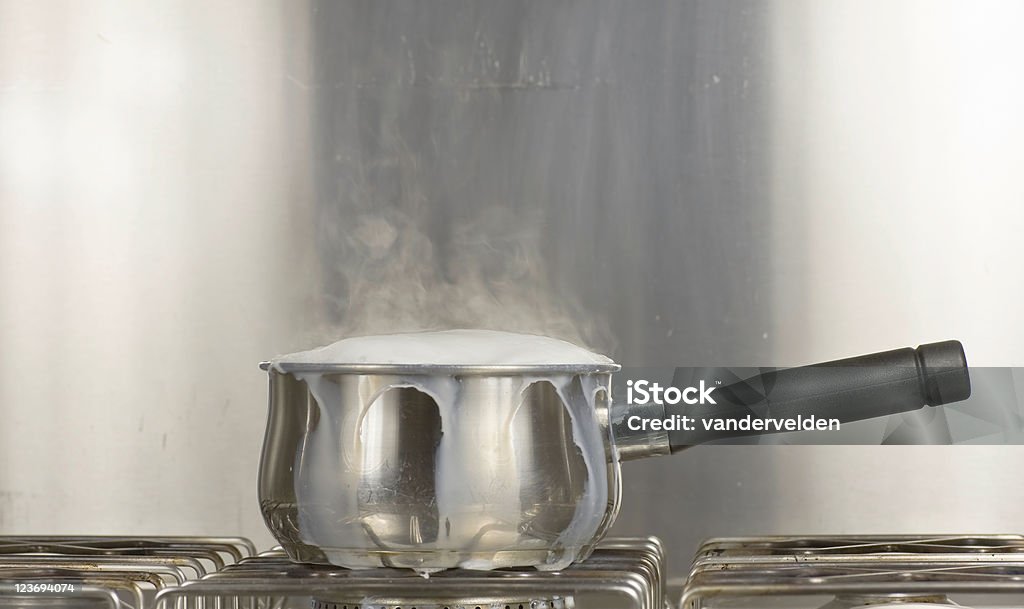 片手鍋を沸騰するミルク - あふれるのロイヤリティフリーストックフォト