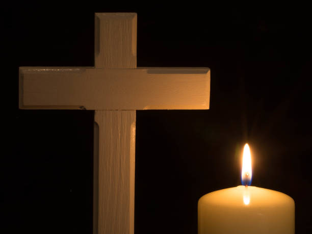 istock Burning candle and cross on black background 1236967432