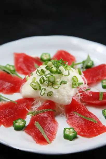 fresh tuna with yam carpaccio on dark background