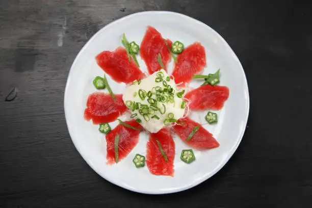 fresh tuna with yam carpaccio on dark background