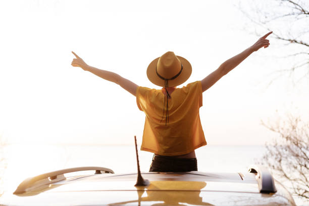 istock Happy Woman Spread Arms Widely at Car Sunroof 1237061421