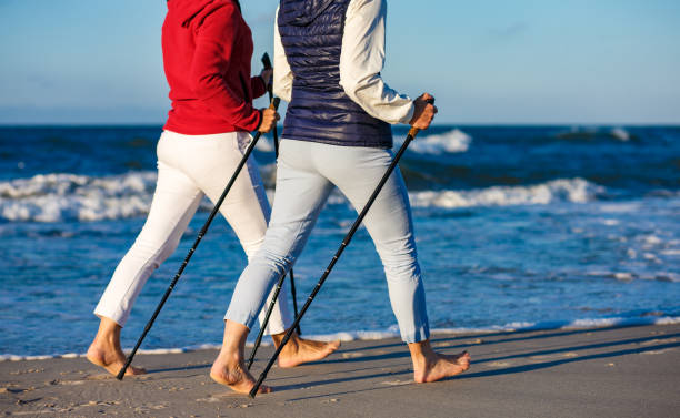 nordic walking - aktive, die am strand arbeiten - power walken stock-fotos und bilder