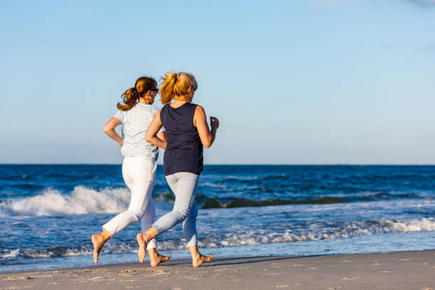 istock Two women running on beach 1237067359