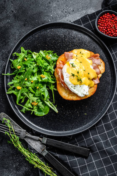 istock Breakfast Burger with bacon, egg Benedict, hollandaise sauce on brioche bun. Black background. Top view 1237076189