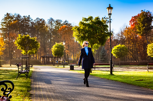 Middle-aged woman walking in city park