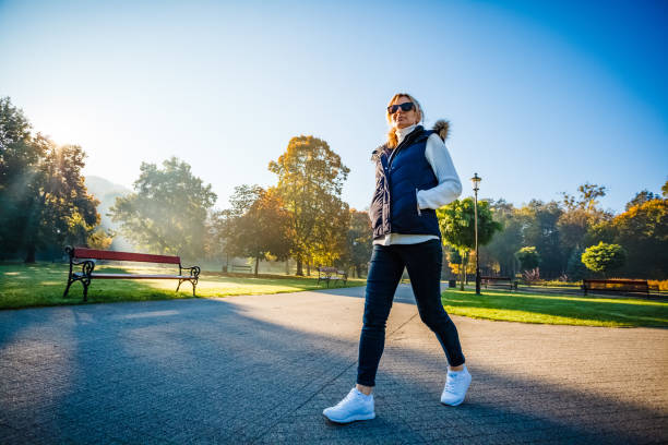 istock Middle-aged woman walking in city park 1237103859