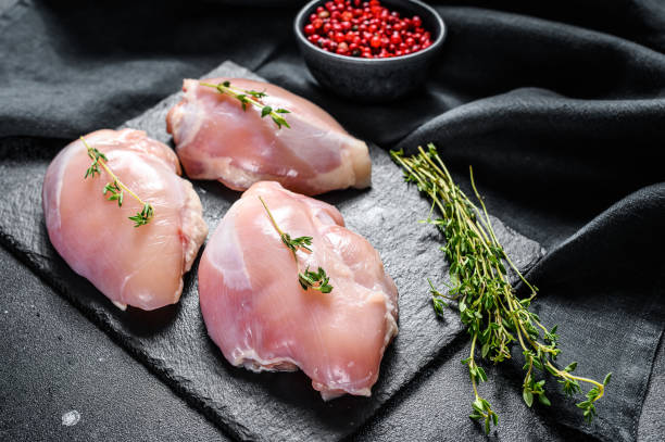 istock Raw boneless chicken thighs fillet. Black background. Top view 1237114992