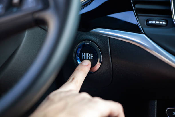 istock Man hand pressing car start and stop button. Hire word is written on the button. 1237124114
