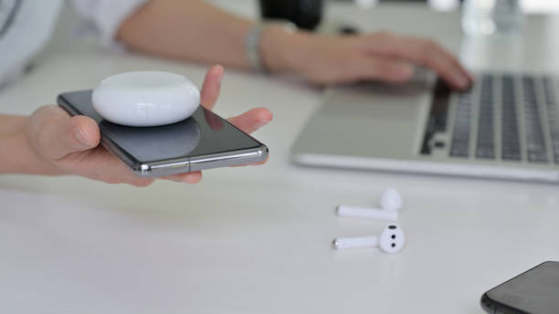 istock Young women put headphones on a smartphone to share a wireless charger. 1237133670