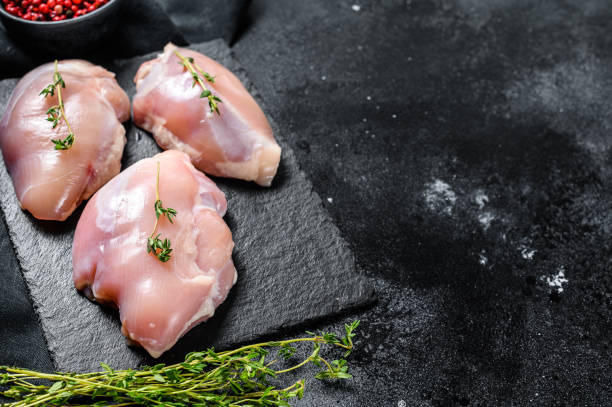 istock Chicken thigh fillet without skin. Black background. Top view. Copy space 1237140498