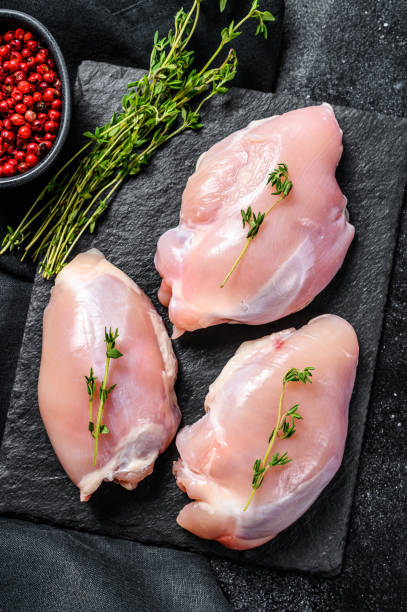 istock Raw boneless chicken thighs fillet. Black background. Top view 1237143653