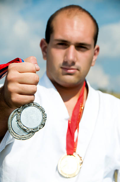 istock Man Wearing White Karate Suit and Holding Medal 123714666