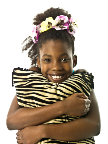 Beautiful afro caribbean little girl holding a pillow no white background (picture shot in super high definition with a Hasselblad HD3 II 31 mpx camera)  