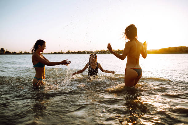 istock Three young girls splashing water in the sea. 1237175670
