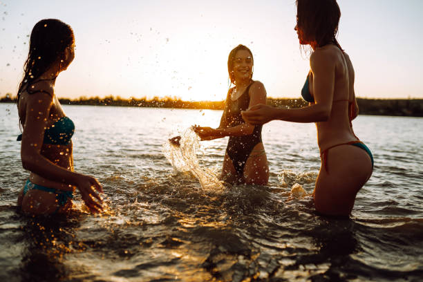 istock Three young girls splashing water in the sea. 1237176199