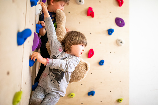 Toddler boy climbing on climbing wall - indoor shot