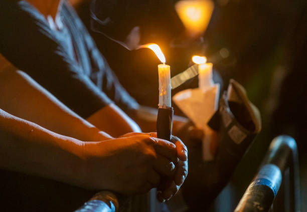 Some of the participants at a candlelit vigil for the 29th anniversary of the Tiananmen Square Massacre. Shot in Victoria Park, Hong Kong on 4th June 2018. A candle being held during a candlelit vigil for the 29th anniversary of the Tiananmen Square Massacre  in Victoria Park, Hong Kong on 4th June 2018. memorial vigil stock pictures, royalty-free photos & images