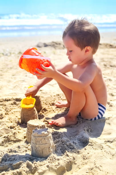 istock a boy plays with sand and builds sand castles on the seashore. summer mood 1237204428