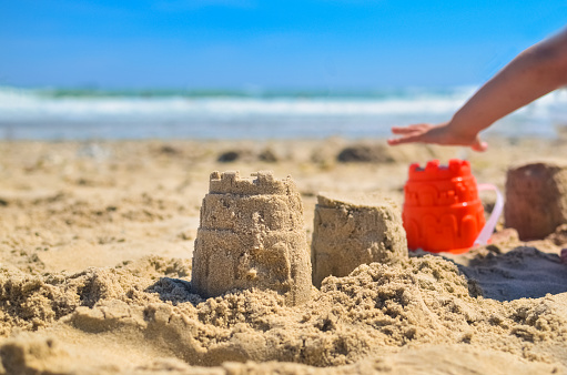 children's hands are playing in the sand against the background of the sea