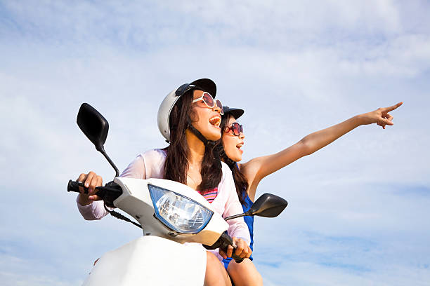 istock happy girls riding scooter 123722451