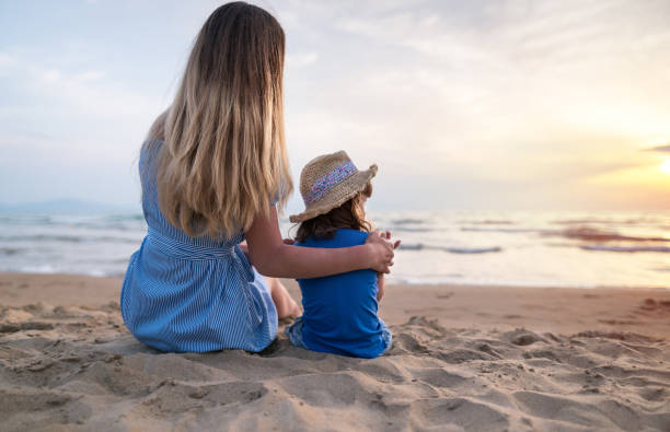 istock Girls on a sandy beach and watching sunset at vacation 1237238717