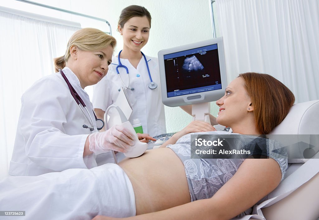 Medical team diagnosing a woman's pregnancy Pregnant woman getting ultrasound from doctor 30-39 Years Stock Photo