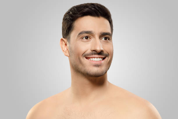 istock Portrait of handsome guy standing without shirt on shoulders, thinking aside with smile and hope, concept of men beauty, isolated on gray background 1237257798
