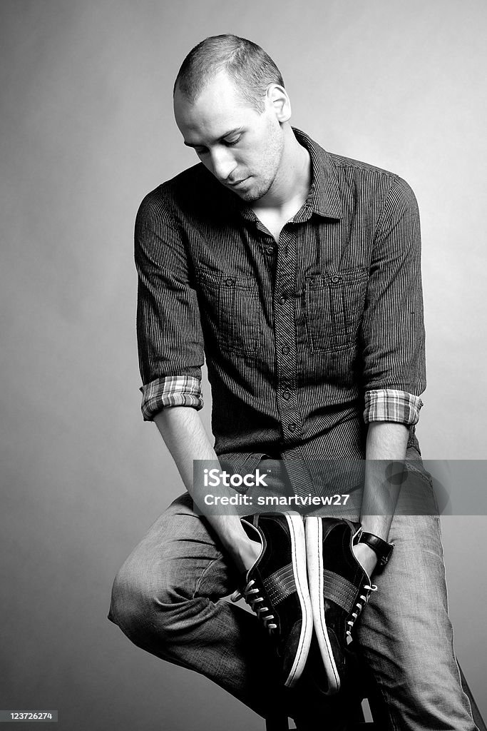 Человек изучает кроссовки - Стоковые фото Вертикальный роялти-фри
