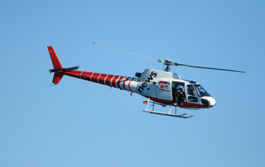 Richmond, Canada - 15th September 2023: C-CHJT, a Sikorsky S-76A helicopter operated by Helijet International with the branding of their charity Helicopters Without Borders, flying against a clear, blue sky. Vancouver South Airport, Richmond, BC,. Canada.