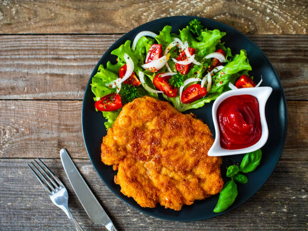 smażony kotlet schabowy i sałatka jarzynowa na drewnianym stole - wiener schnitzel zdjęcia i obrazy z banku zdjęć