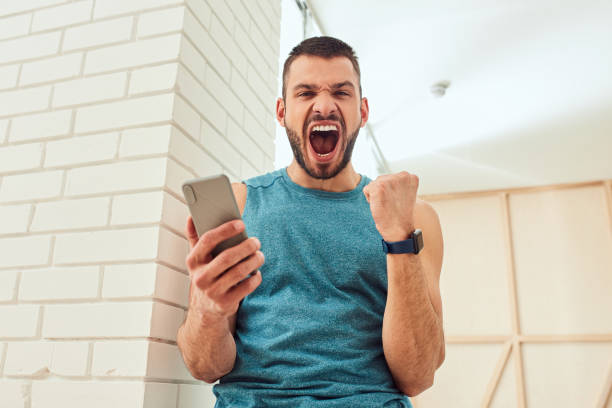 istock Excited gentleman holding cellphone and screaming with joy 1237299649