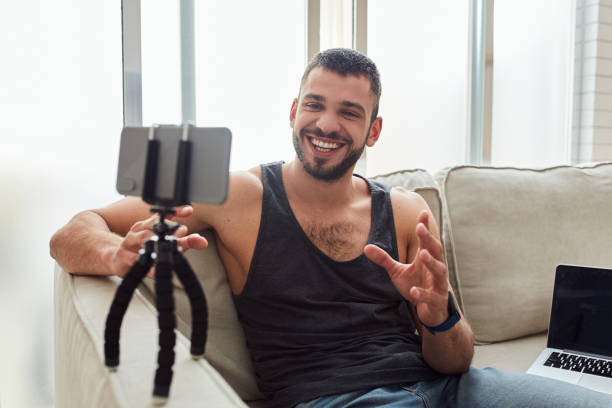 istock Cheerful young man talking with friend through video call 1237300727