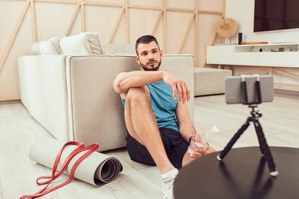 istock Handsome gentleman watching online workout on smartphone 1237300741