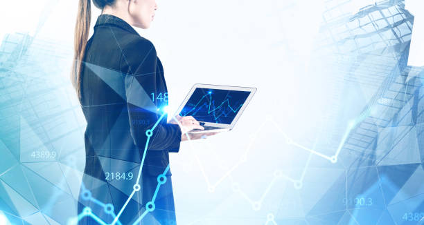 istock Woman with laptop in city, financial graph 1237301815