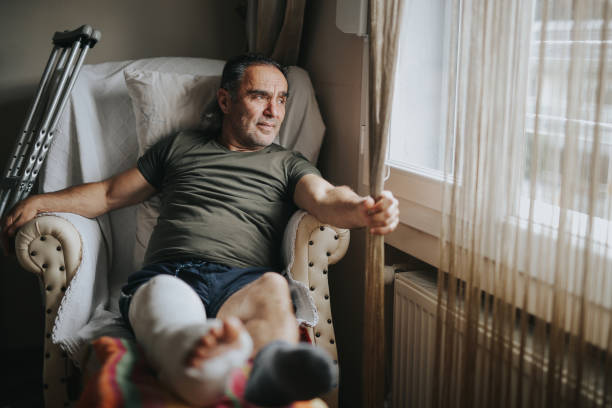 hombre con la pierna rota en casa - physical impairment smiling front view looking at camera fotografías e imágenes de stock