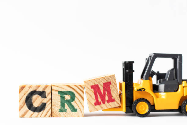 istock Toy forklift hold wood letter block M to complete word CRM (Abbreviation of Customer Relationship Management) on white background 1237324369