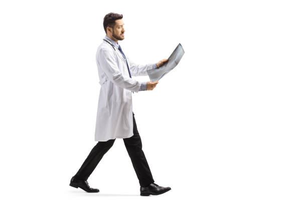 istock Male doctor walking and looking at x ray scan 1237362228