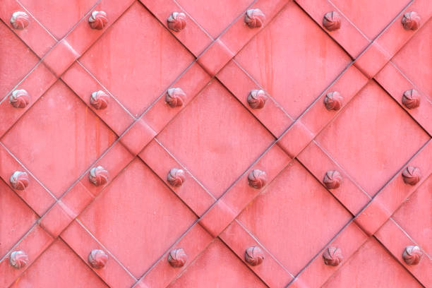 Pink surface of wrought iron doors. Vintage metallic texture background.