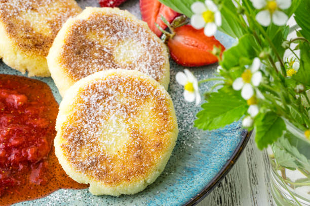 istock Close cheese pancakes, syrniki, curd fritters with fresh strawberries on plate background 1237385334