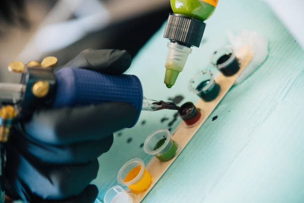 istock Female tattooist loading the tattoo machine with ink. 1237426250