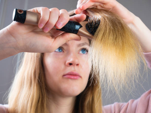 istock Young woman combs her brown hair using the brush 1237450053