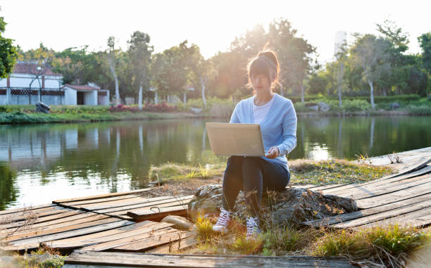 istock Woman using laptop by the lake 1237455863
