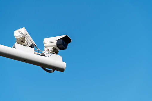 Security cameras under blue sky.